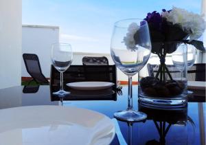 a table with two wine glasses and a vase of flowers at Dunas Jewel Apartment in Morche