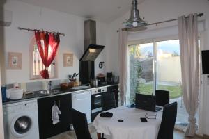 a kitchen with a table and a sink and a stove at Un petit coin de Paradis in Mazan