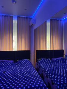 a bedroom with two beds and a blue light at Olesi Gonhara in Dnipro