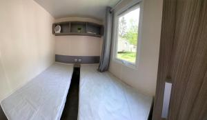 un couloir étroit avec une fenêtre dans une petite maison dans l'établissement Mobil home climatisé 6 personnes dans camping 3* Tohapi a BOOFZHEIM, à Boofzheim