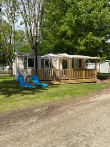 un mobile home avec une terrasse et deux chaises dans l'établissement Mobil home climatisé 6 personnes dans camping 3* Tohapi a BOOFZHEIM, à Boofzheim