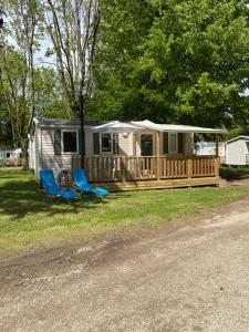 a mobile home with a deck and two chairs at Mobil home climatisé 6 personnes dans camping 3* Tohapi a BOOFZHEIM in Boofzheim