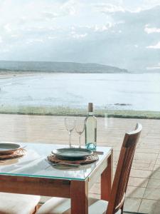 un tavolo con due bicchieri e una bottiglia di vino di At The Beach Rooms a Portstewart