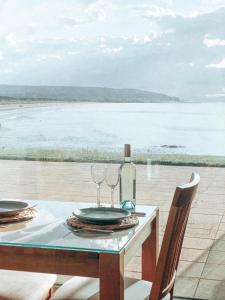 uma mesa com dois copos e uma garrafa de vinho em At The Beach Rooms em Portstewart