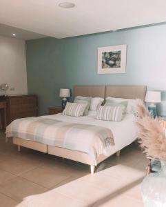 um quarto com uma cama grande e 2 almofadas em At The Beach Rooms em Portstewart