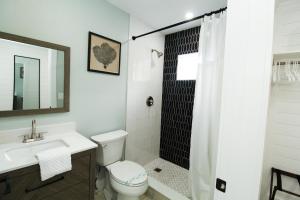 a bathroom with a toilet, sink, and shower at Pelican Post at Anna Maria Island Inn in Bradenton Beach