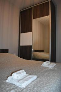 a bed with white towels on it with a mirror at Apartmani Trklja in Trebinje