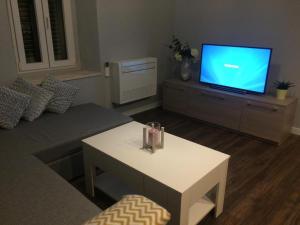 a living room with a tv and a white coffee table at Apartmani Trklja in Trebinje