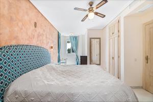 um quarto com uma cama e uma ventoinha de tecto em Townhouse at Los Naranjos GC em Marbella