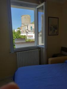 - une chambre avec une fenêtre donnant sur une tour dans l'établissement Casa La Torre Forio d'Ischia - Vicoli Saraceni, à Ischia