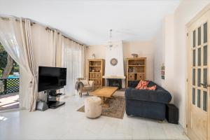 a living room with a couch and a tv at Townhouse at Los Naranjos GC in Marbella
