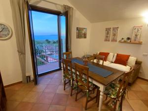 sala de estar con mesa, sillas y sofá en Tyrrhenian Sea Apartment, en Torre Faro