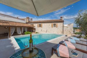 a villa with a swimming pool with a bottle of wine at Casa Jagoda in Višnjan