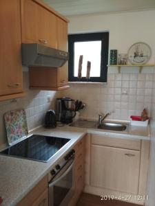a kitchen with a sink and a stove top oven at Ferienhaus Ostkannt in Neuharlingersiel