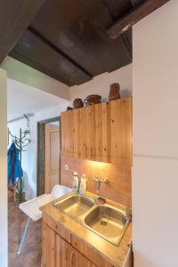 a kitchen with a stainless steel sink and wooden cabinets at Csavargó Tanya in Szalafő