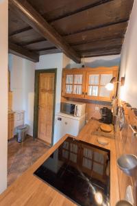 a kitchen with wooden cabinets and a counter top at Csavargó Tanya in Szalafő