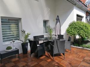 une terrasse avec une table, des chaises et un parasol dans l'établissement Ferienhaus Resit 1, à Steinhude