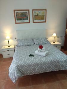 Un dormitorio con una cama con un animal de peluche encima. en ARCO DE VILLALAR, en Baeza