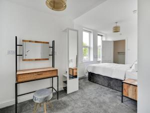 1 dormitorio con cama, escritorio y espejo en Albert View Rooms, en Mánchester