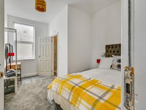 a bedroom with a white bed and white walls at Albert View Rooms in Manchester