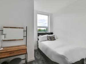 1 dormitorio con cama y ventana en Albert View Rooms en Mánchester