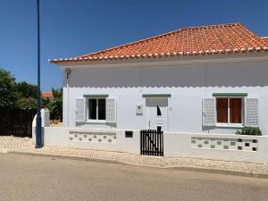 une maison blanche avec une clôture devant elle dans l'établissement Casa Fagundes com 3 Quartos, à Sagres