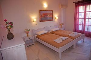 a bedroom with two beds with towels on them at St.George Valsamitis in Katapola