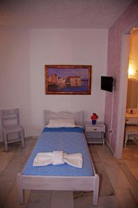 a bedroom with a bed with towels on it at St.George Valsamitis in Katapola