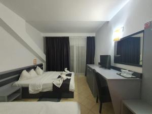 a hotel room with a bed and a desk at Vila Blue Lagoon in Eforie Nord