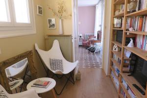 ein Wohnzimmer mit weißen Stühlen und einem TV in der Unterkunft B&B Le Patio En Ville - Chambres d'hôtes in Narbonne