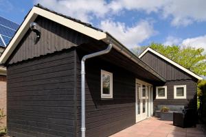 a black house with a gutter at Vakantiehuis 't Laaisterplakky zonder drempels in Oude Bildtzijl