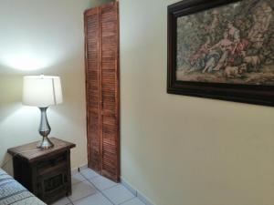 a bedroom with a painting on the wall and a lamp at Hotel Chely in Bernal