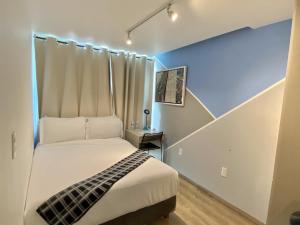 Un pequeño dormitorio con una cama y una escalera en Kubo Hotel, en San Miguel de Allende