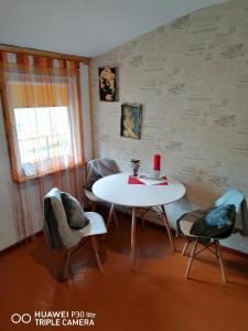 a room with a white table and chairs and a window at Imantas in Salacgrīva