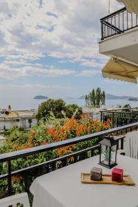 a table on a balcony with a view of flowers at Sunrise Apartment in Paleo Tsifliki