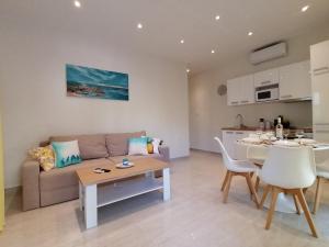 un soggiorno e una cucina con divano e tavolo di Sea Pleasure Apartment a Perea