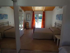 a bedroom with two beds in a room with a window at Villa Angelina Garden in Grimaud