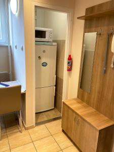 a small kitchen with a refrigerator and a microwave at Center One Apartman in Debrecen