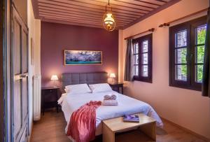 um quarto com uma cama branca e 2 janelas em Zissis Hotel em Aristi