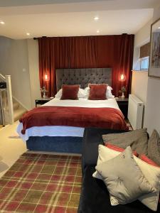a bedroom with a large bed and a couch at Bootmenders B&B in Petersfield