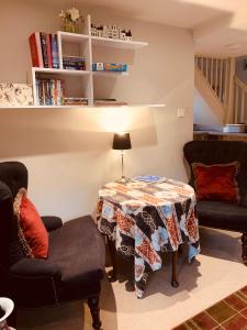 a living room with a table and two chairs at Bootmenders B&B in Petersfield
