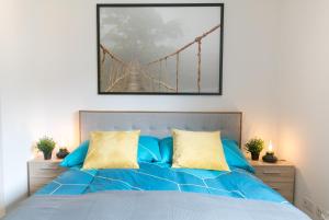 um quarto com uma cama azul e uma ponte suspensa em Spirit Apartments - Neben dem Titlis - Parkplatz em Engelberg