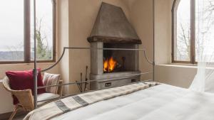 um quarto com uma lareira, uma cama e uma cadeira em Castello di Gabiano em Gabiano