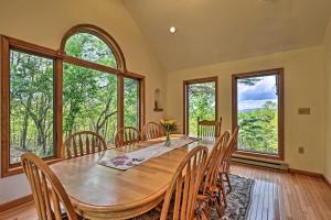 a dining room with a table and chairs and windows at Bedford House on 1 Acre with Deck, Views! in Bedford