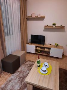 a living room with a table and a television at Apartman Rada 2 in Bijeljina