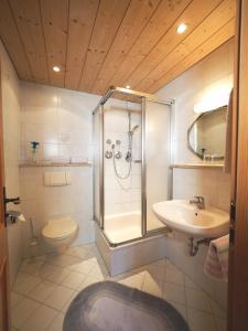 a bathroom with a shower and a toilet and a sink at Haus Hölzl Ferienwohnungen in Ramsau
