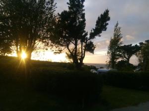 a sunset on top of a hill with trees at Dortoire en tente individuelle in Plestin-les-Grèves