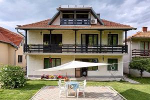 a house with a table and chairs in the yard at Apartmani Stanojevic Sokobanja in Soko Banja