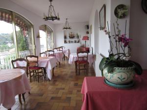 un restaurante con mesas y sillas y un jarrón con flores en Hotel Belle Vue, en Le Lavandou