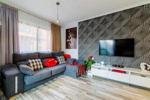 een woonkamer met een bank en een flatscreen-tv bij La Perla De Torrevieja in Torrevieja